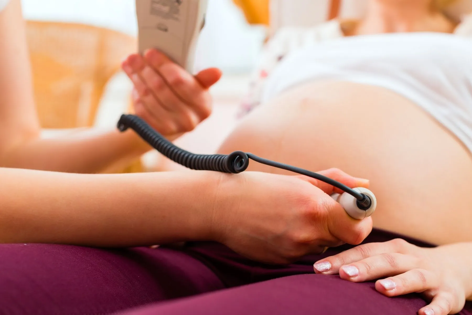 Die Herztöne eines Babys werden mit einem Doppler am Bauch abgehört – Symbolbild für die Schwangerschaftsvorsorge
